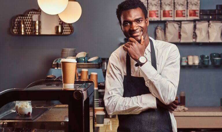 Handsome African barista at coffee shop.